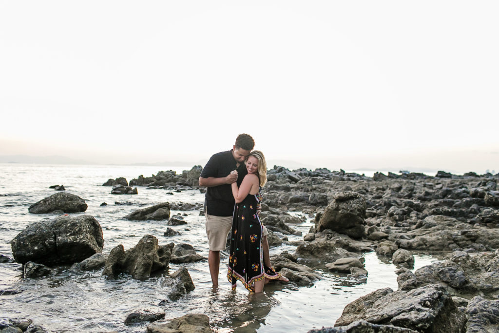 Newlyweds on rocks at sunset